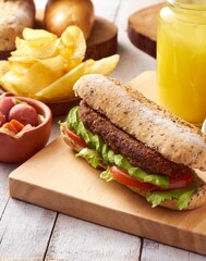 Sánduche vegano con aguacate en pan integral con jugo, papas fritas y encurtido acercamiento.