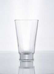 Vaso de cristal con forma para jugos naturales en fondo blanco gris 