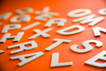 Mixed letters pile close up view. Orange background