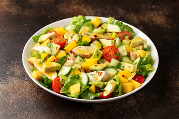 Tasty Chicken mango salad with avocado, cucumber, cherry tomatoes. Healthy food