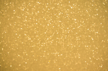 Gold glitters background. shimmering blur spot lights Bokeh Shiny gold light background.