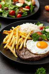Portugal dish Bitoque made from beef steak with a fried egg, rice, french fries and vegetables