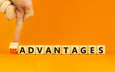 Advantages or disadvantages symbol. Businessman turns a wooden cube, changes the word Disadvantages...