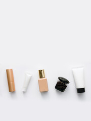 vertical flatley background: lipstick, eye cream, foundation, perfume and moisturizing face mask. Online shopping beauty concept