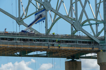 Construction crew repairing a large steel bridge