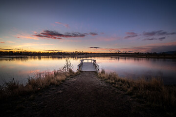 Sunrise over a dock on a pond