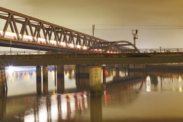 Fototapeta na wymiar scenic night shot of a railway bridge over a river