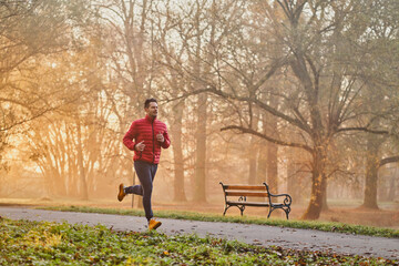 Man jogging in the park on sunny autumn morning
