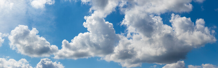 White cumulus clouds in the blue sky on a sunny day