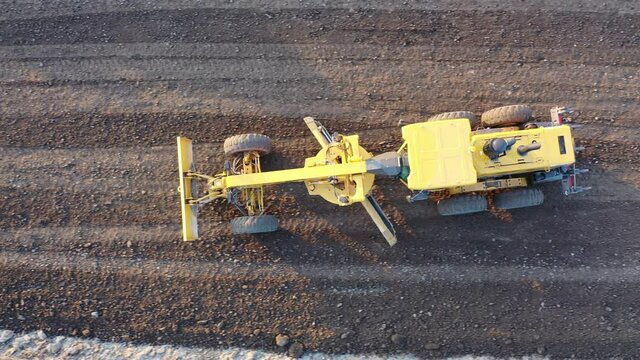 Grader Road Construction Grader industrial machine on construction of new roads. the blade of a motor grader in the process of leveling a sandy road foundation. Grader is working on road construction.