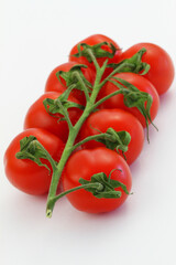 Sweet and juicy cherry tomatoes on stem on white background
