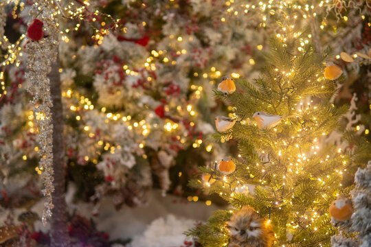 toy birds sitting on a tree with lights. Christmas installation