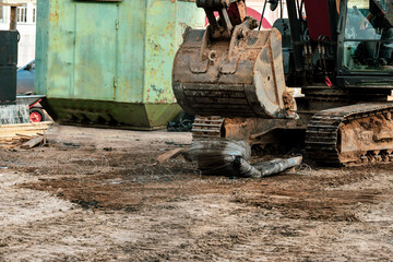 Repair and replacement of the road surface in the city square. The excavator crushes the iron before loading.