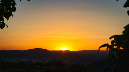 Sunset in Saarland with the view of a valley. Warm light mood