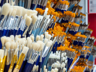 Group of artistic paintbrushes for artist. New paint brushes on shelf display in stationery shop. Art painting concept. The concept of selling tools for artists, the choice of brushes.