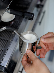 barista pouring cream into coffee - 457905433