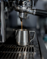 coffee machine pours coffee into a metal cup - 457905665