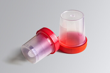 Plastic test jars with red lids on a light background