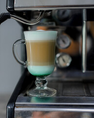 three-layer coffee standing on the coffee machine - 457905878