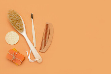 Bathroom accessories with zero waste, natural bristle brush, wooden toothbrush, bars of solid soap, wooden comb, with a palm leaf on a beige background