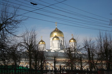 
Photo of the Russian Orthodox Church. White church with golden domes against a bright blue sky...