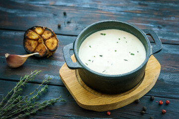 Roasted garlic cream sauce on rustic old table 