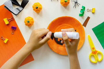 Cuts of paper for Halloween. Hand cut paper. Pumpkins. Scissors and glue. On a light background. Top view. Flat lay. DIY. Step by step