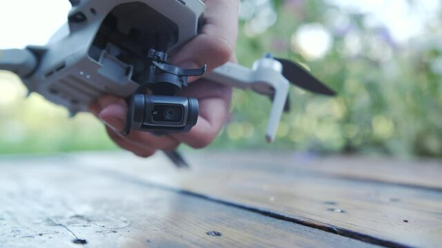 Man inspecting broken drone gimbal and camera