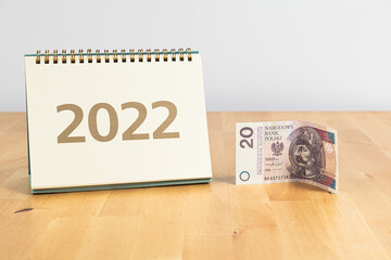 20 PLN (twenty Polish zlotys and 2022 calendar cover on wooden table