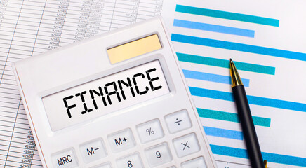 Against the background of reports and blue graphs, a pen and a white calculator with a test on the FINANCE screen. Business concept