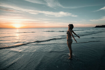 Fototapeta na wymiar A woman sees off the sun on a tropical island dreaming beach.