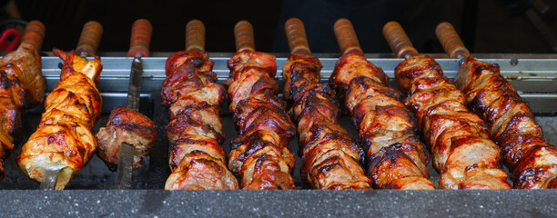 Cooking meat on coals. Appetizing juicy meat is grilled on skewers. Fry the meat on charcoal in an open fire in the grill. Horizontal image