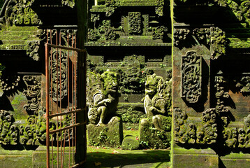 Moss-covered stonework of Pura Bukit Sari, Sangeh, Bali, Indonesia