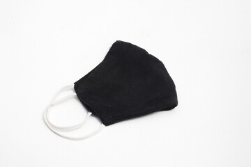 Reusable black cloth mask with white strap for preventing Covid-19 spreads isolated on white background.
