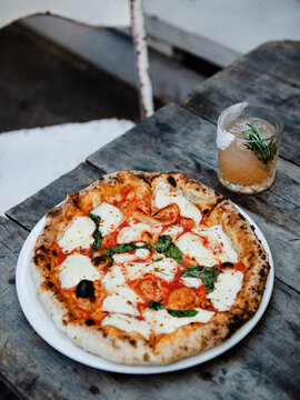 Gourmet Margherita pizza with a grapefruit cocktail