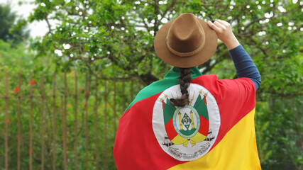 Brazilian woman with hat and flag of the state of Rio Grande do Sul - Sul do Brasil. Farroupilha Week of the gauchos.