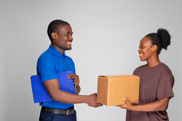 african woman shakes had with a delivery worker after receiving a package