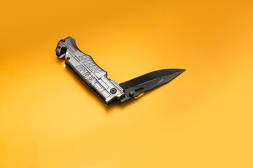 Stainless Folding Knife isolated on orange background