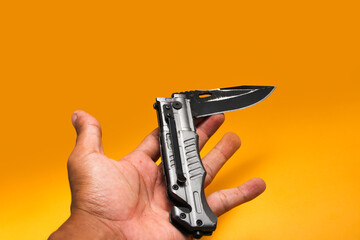 Obraz premium Stainless Folding Knife isolated on orange background