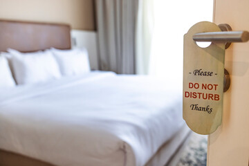 The hotel room with DO NOT DISTURB sign on the door. Closed door of hotel room with please do not...
