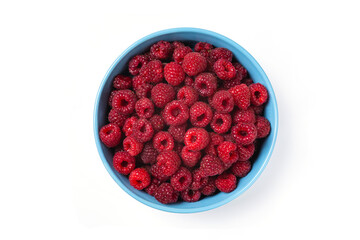 Red raspberry berry in plate on wooden table.