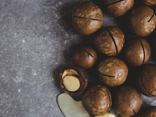 pile of macadamia nuts close up on gray concrete background, copy space