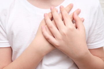 A boy showing gratitude gesture on white background, he is hopeful while praying