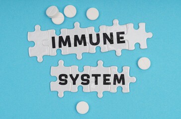 On a blue background pills and puzzles with the inscription - IMMUNE SYSTEM