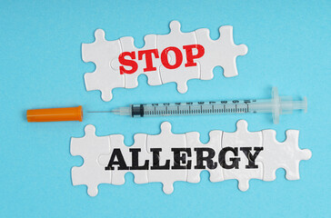 On a blue background, a syringe and puzzles with the inscription - STOP ALLERGY