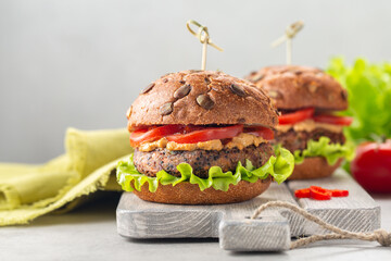 Veggie burger made from quinoa, beans, peanut sauce and tomatoes. Light backgroun, copy space.