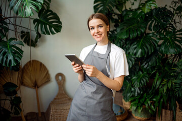 The florist works in his workshop. A woman surfs the Internet looking for information about plants. The agronomist grows popular flowers. The special form is convenient.