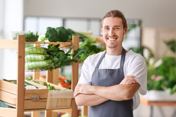 Male seller with fresh vegetables in market