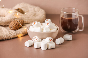 Obraz na płótnie Canvas Bowl with snowmen made of soft marshmallows on color background
