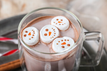 Snowmen made of soft marshmallows and cup of hot chocolate on table, closeup